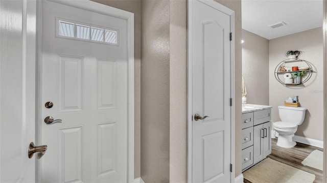 bathroom featuring vanity, wood-type flooring, and toilet