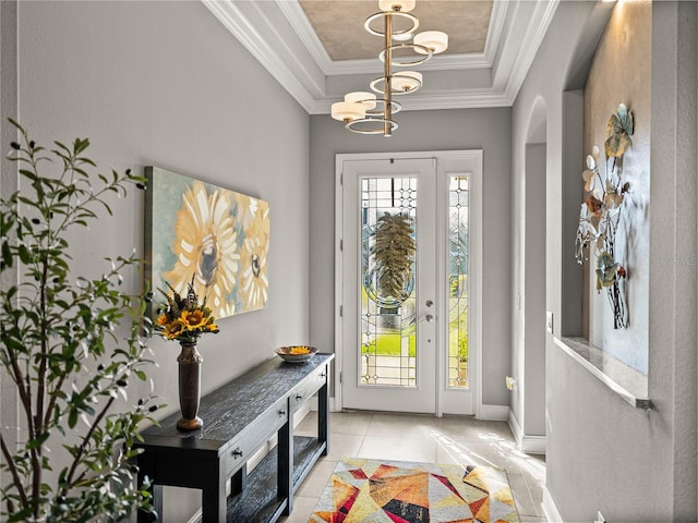 foyer featuring a raised ceiling, light tile patterned flooring, crown molding, and a notable chandelier