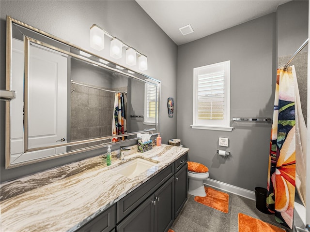 bathroom with curtained shower, vanity, and toilet