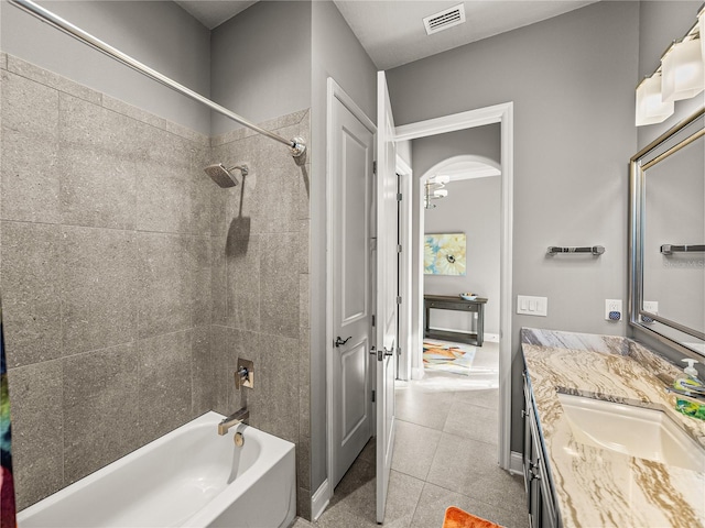 bathroom featuring vanity, tile patterned flooring, and tiled shower / bath combo