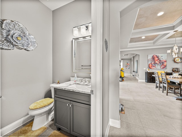 bathroom with toilet, beam ceiling, coffered ceiling, and vanity