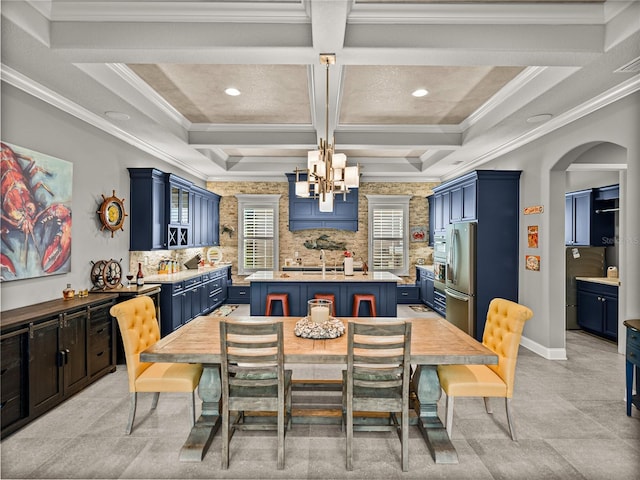 dining space featuring coffered ceiling, ornamental molding, a notable chandelier, beam ceiling, and sink