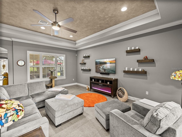 living room with a raised ceiling, ceiling fan, and ornamental molding