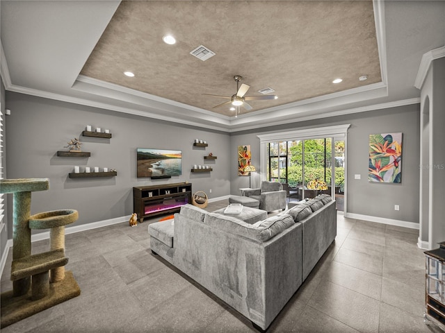 living room featuring ceiling fan, crown molding, and a raised ceiling