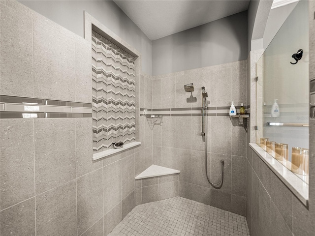 bathroom featuring tile walls and a tile shower