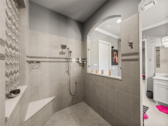 bathroom with tiled shower, crown molding, and vanity