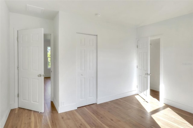 unfurnished bedroom featuring light hardwood / wood-style floors and a closet