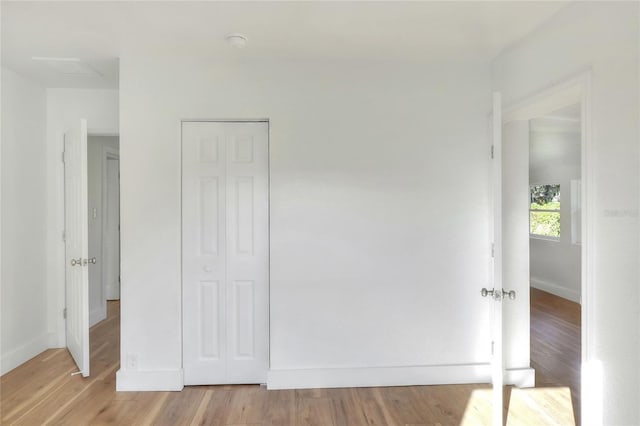 unfurnished bedroom with light wood-type flooring and a closet