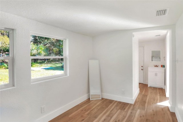 spare room with sink and light wood-type flooring