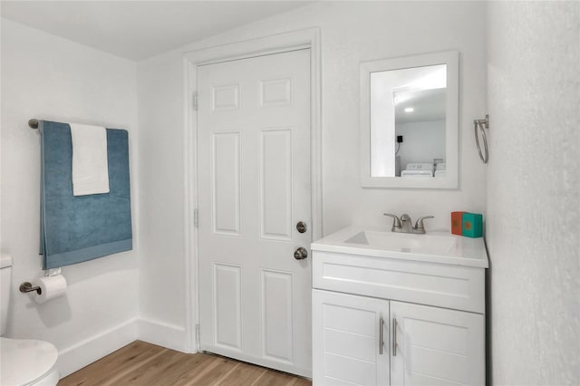 bathroom featuring hardwood / wood-style floors, vanity, toilet, and washer / dryer