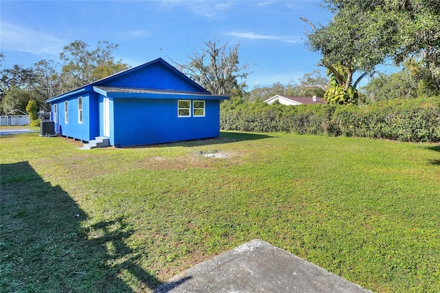 view of home's exterior featuring central AC unit and a yard