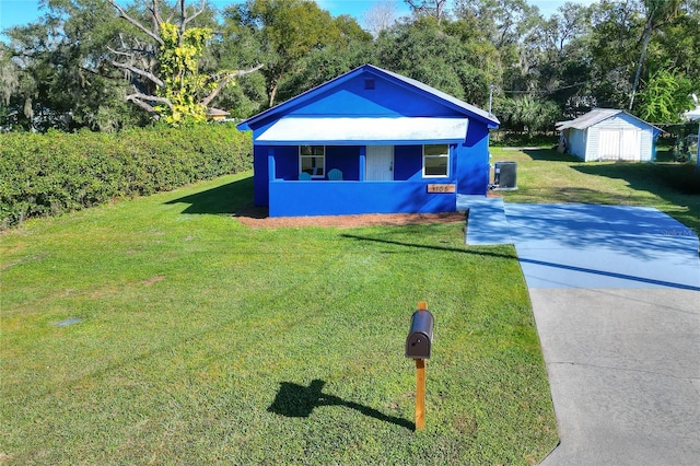 view of front facade with a storage unit, cooling unit, and a front lawn