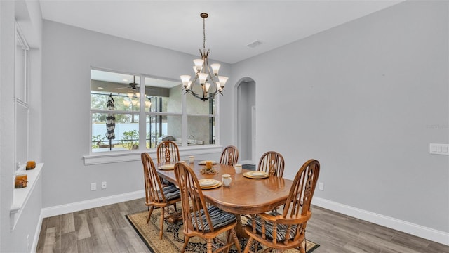 dining space featuring ceiling fan with notable chandelier and hardwood / wood-style flooring