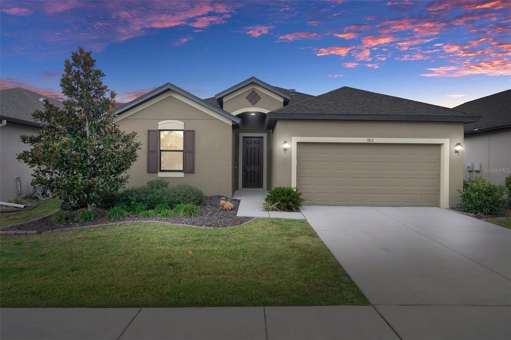 ranch-style house with a yard and a garage