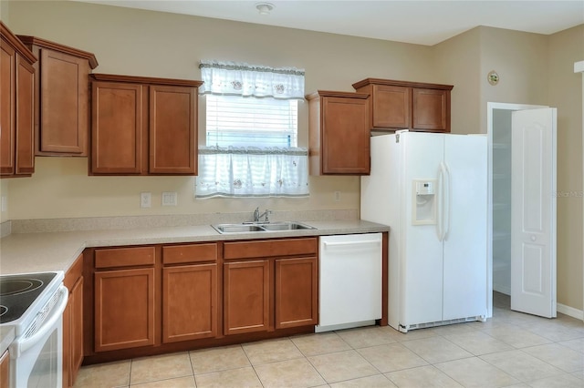 kitchen featuring light tile patterned floors, white appliances, and sink