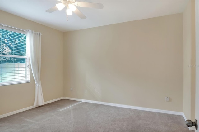 spare room featuring light colored carpet, plenty of natural light, and ceiling fan