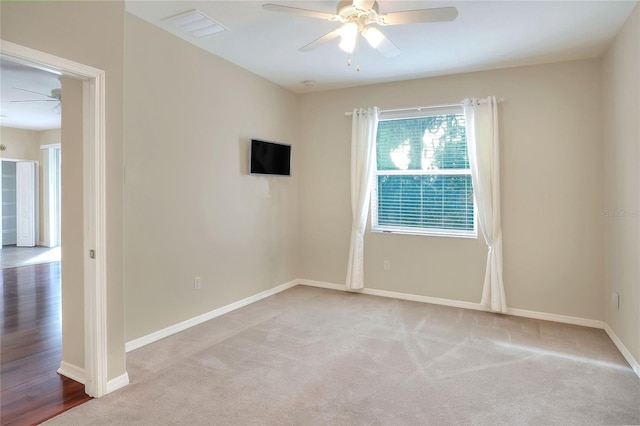 carpeted spare room featuring ceiling fan