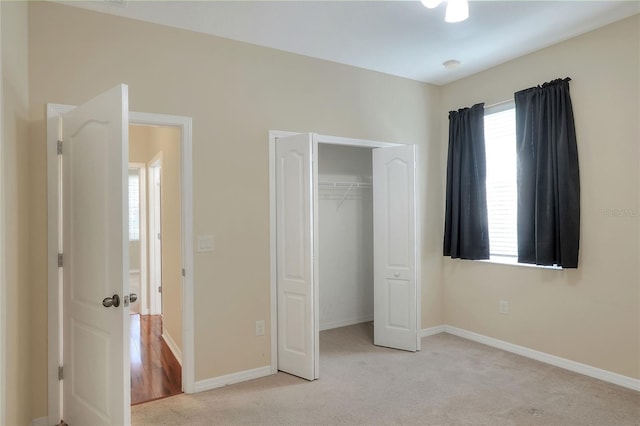 unfurnished bedroom featuring a closet and light colored carpet