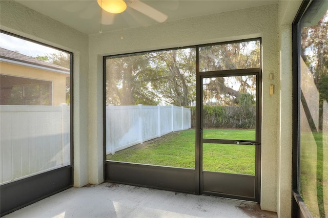 unfurnished sunroom featuring ceiling fan