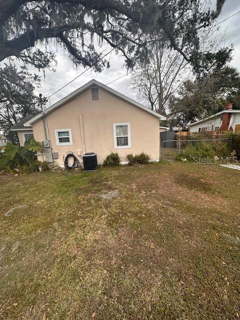 view of side of home featuring a yard and central air condition unit