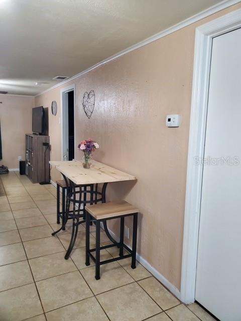 tiled dining room with ornamental molding