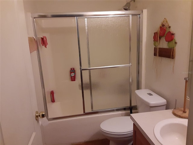 full bathroom featuring vanity, toilet, and shower / bath combination with glass door