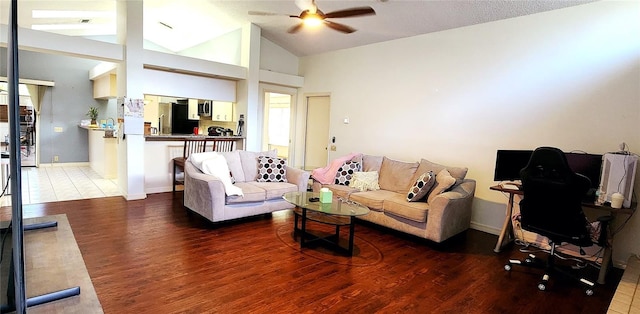 living room featuring dark hardwood / wood-style flooring, vaulted ceiling, and ceiling fan