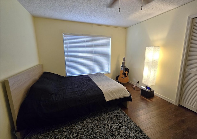 bedroom featuring ceiling fan, wood-type flooring, and a textured ceiling