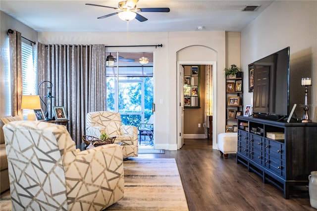 living room with ceiling fan and dark hardwood / wood-style flooring