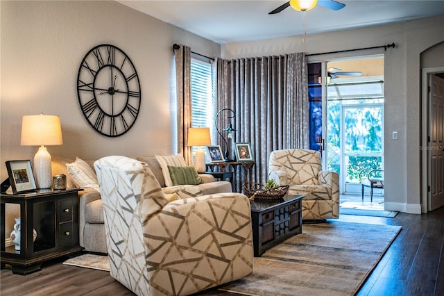 living room with dark hardwood / wood-style flooring and ceiling fan