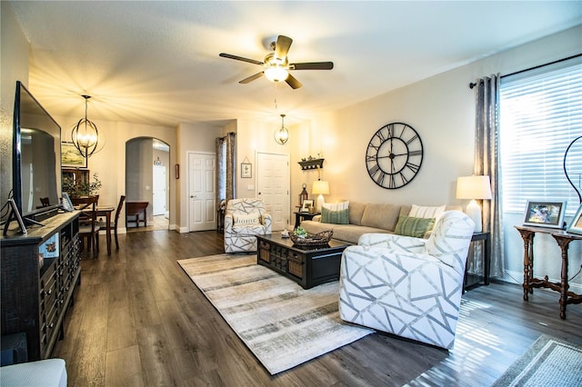 living room featuring dark hardwood / wood-style floors and ceiling fan with notable chandelier