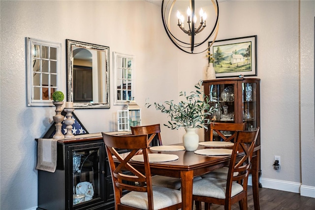 dining space featuring dark hardwood / wood-style floors and a chandelier