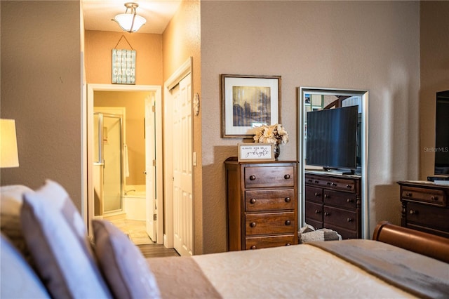 bedroom with ensuite bathroom and light hardwood / wood-style floors