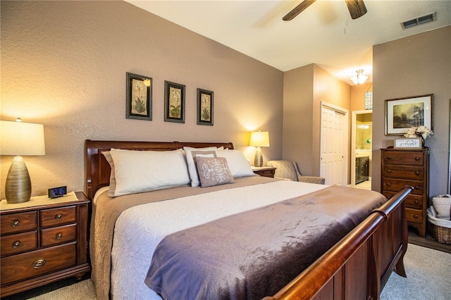 bedroom featuring ensuite bathroom, a closet, light colored carpet, and ceiling fan