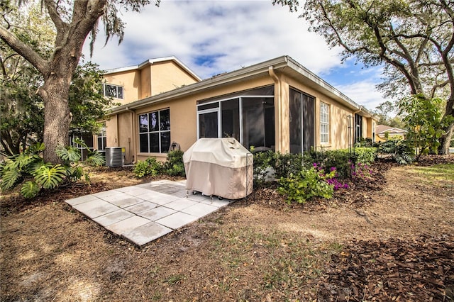 rear view of property featuring a patio, central AC, and a sunroom