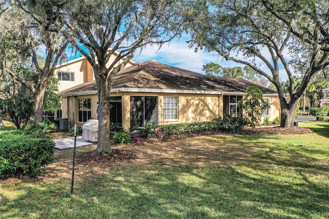 view of front facade featuring a front lawn and central AC