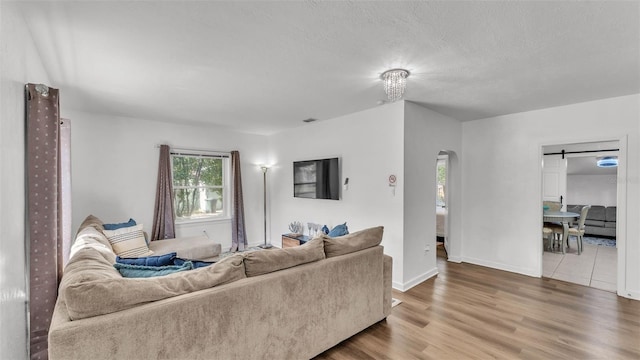 living room featuring hardwood / wood-style floors, a barn door, and a textured ceiling