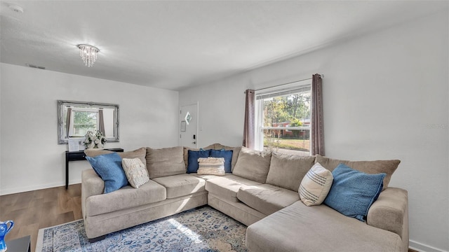 living room with hardwood / wood-style flooring and a notable chandelier