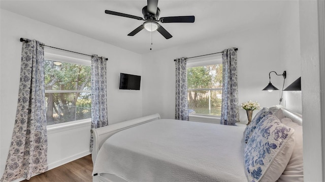 bedroom featuring multiple windows, ceiling fan, and dark hardwood / wood-style floors