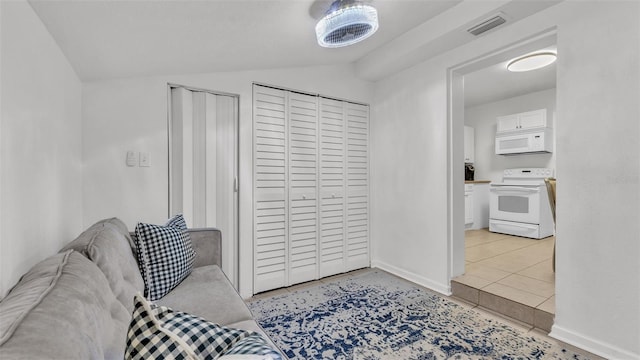 living room featuring light tile patterned flooring and vaulted ceiling