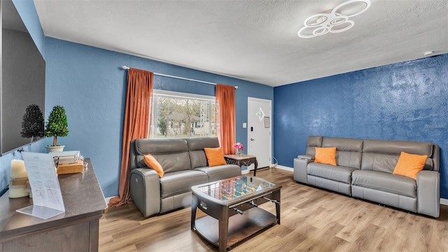 living room with a textured ceiling and light hardwood / wood-style flooring