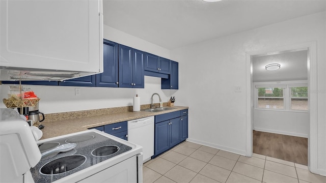 kitchen with blue cabinets, dishwasher, light tile patterned floors, and sink