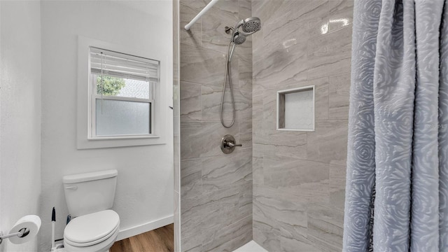 bathroom featuring curtained shower, toilet, and wood-type flooring