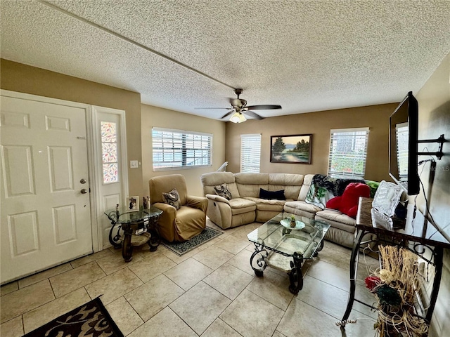 tiled living room with ceiling fan, a healthy amount of sunlight, and a textured ceiling