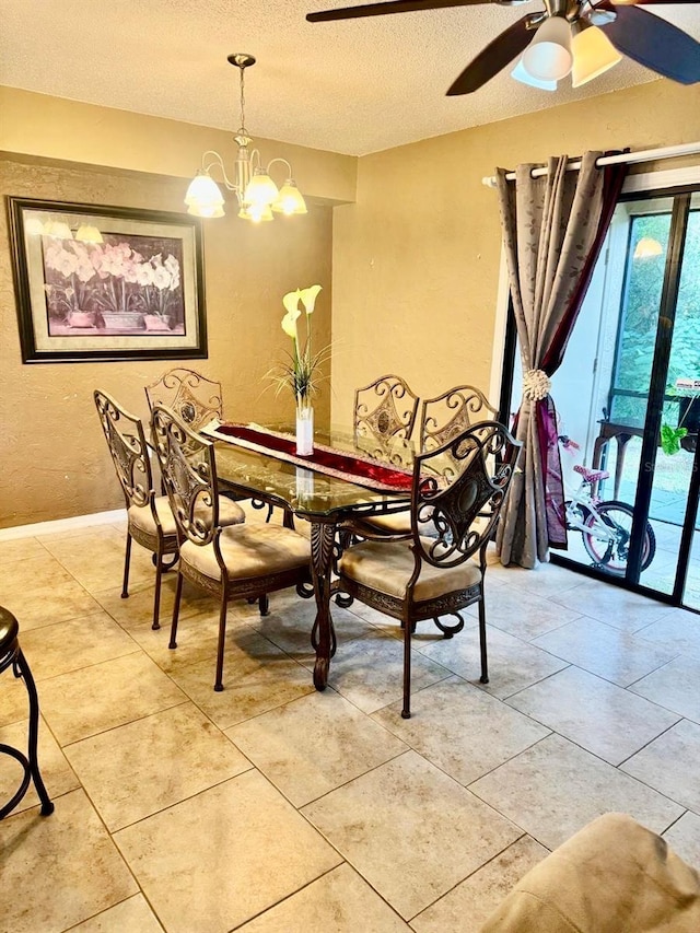 dining area featuring ceiling fan with notable chandelier, light tile patterned floors, and a textured ceiling