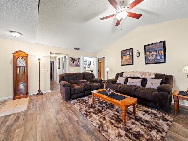 living room with a textured ceiling, ceiling fan, vaulted ceiling, and hardwood / wood-style flooring