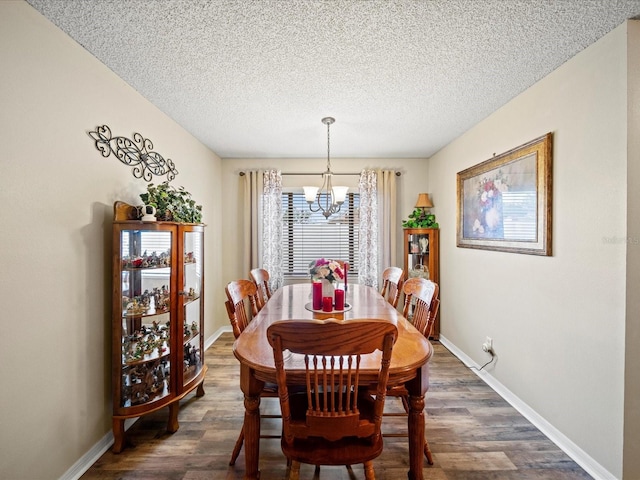 dining room featuring a textured ceiling, dark hardwood / wood-style floors, and an inviting chandelier