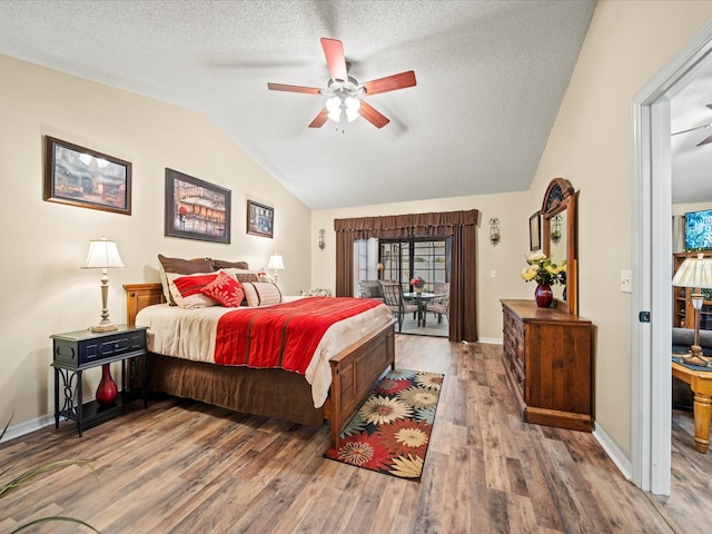 bedroom featuring a textured ceiling, hardwood / wood-style flooring, vaulted ceiling, and ceiling fan