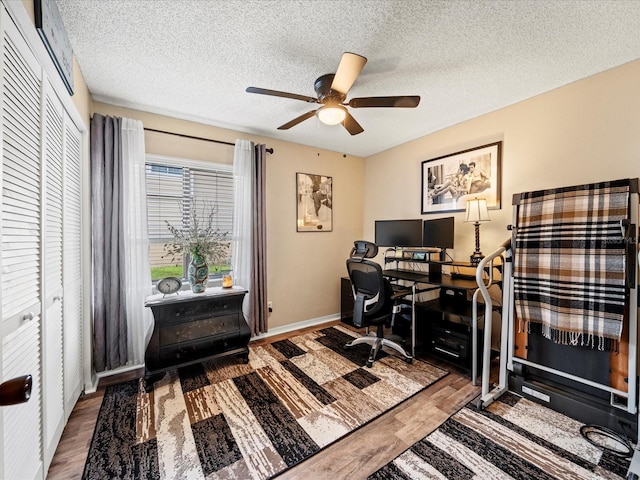 office featuring a textured ceiling, hardwood / wood-style flooring, and ceiling fan