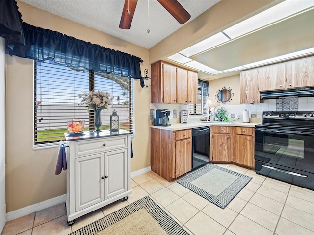 kitchen featuring backsplash, light tile patterned floors, black appliances, and a textured ceiling